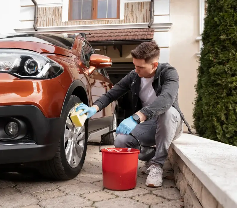 Lavage auto à domicile Bourg-l'Évêque : professionnel intervenant sur un véhicule